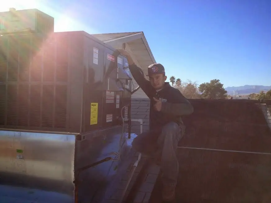 HVAC technician performing Boiler Repair on a rooftop unit in Kosciusko